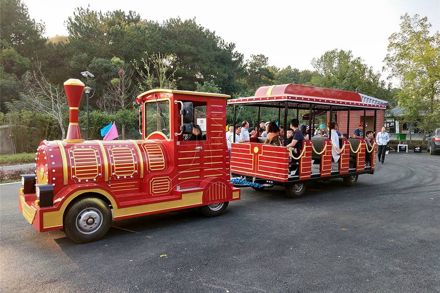 trackless road train in operation at a park with visitors